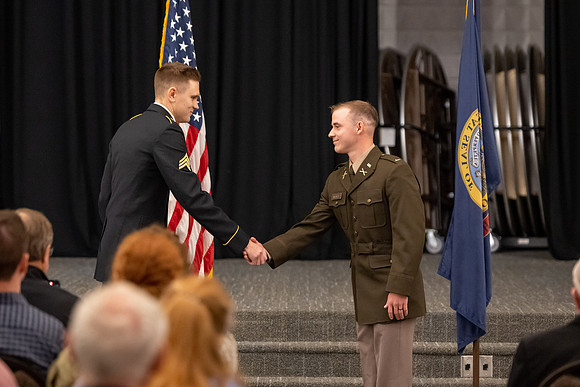 Four graduates from the BYU-Idaho ROTC program gather with the families and have a ceremonial commissioning.