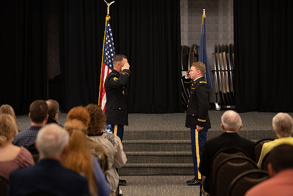 Four graduates from the BYU-Idaho ROTC program gather with the families and have a ceremonial commissioning.
