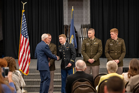 Four graduates from the BYU-Idaho ROTC program gather with the families and have a ceremonial commissioning.