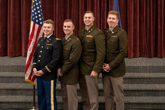 Four graduates from the BYU-Idaho ROTC program gather with the families and have a ceremonial commissioning.