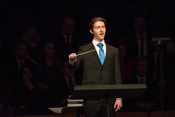 A student conducts the music at Devotional.
