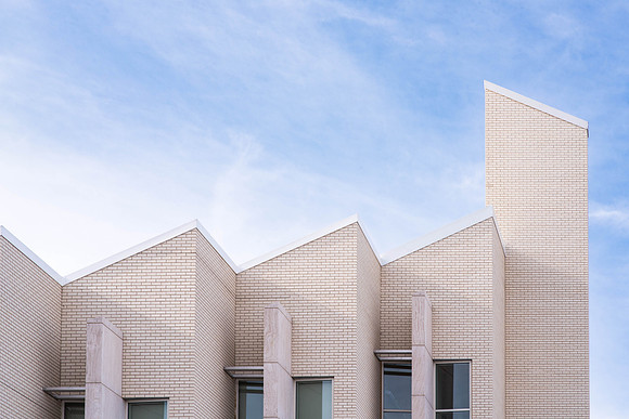 The pointed top of the Taylor building reaches into the blue sky.
