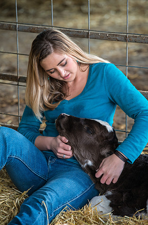 Britton Braithwaite caring for a calf at the Agriculture Science Center.