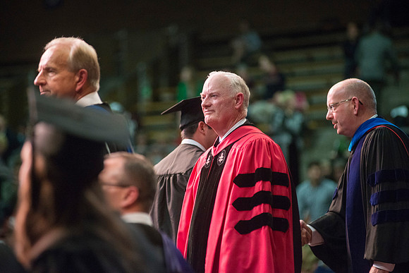 Elder W. Craig Zwick and President Kim B. Clark award diploma covers to graduates in the College of Business and Communication.