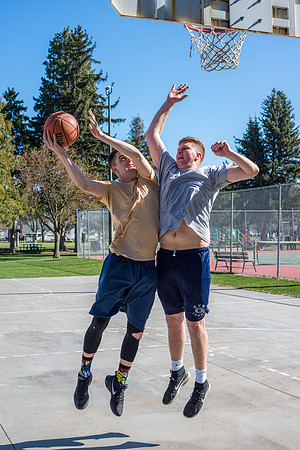 Jacob Kaiser (in yellow) playing basketball, one on one with Jacob Madsen at Smith Park in Rexburg, Idaho.
