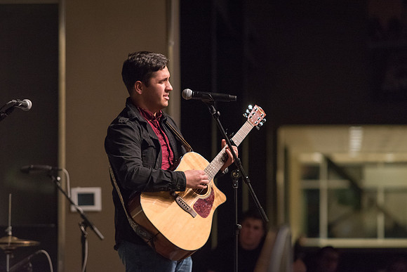 Students perform songs to an audience in the Crossroads at Acoustic Cafe.