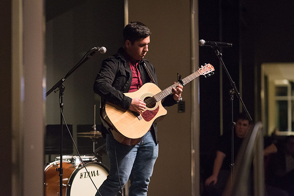 Students perform songs to an audience in the Crossroads at Acoustic Cafe.
