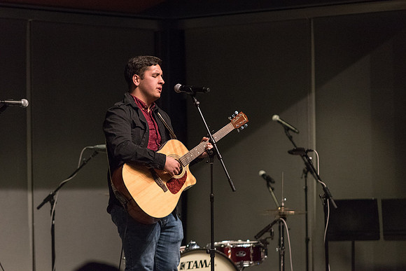 Students perform songs to an audience in the Crossroads at Acoustic Cafe.