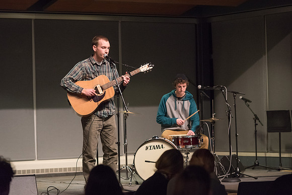 Students perform songs to an audience in the Crossroads at Acoustic Cafe.