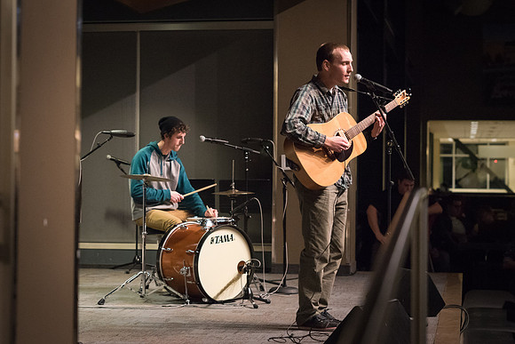 Students perform songs to an audience in the Crossroads at Acoustic Cafe.