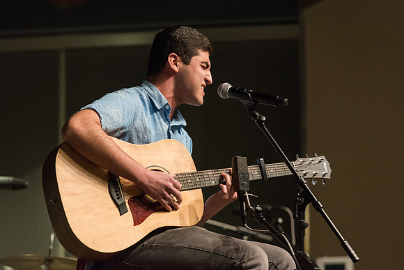 Students perform songs to an audience in the Crossroads at Acoustic Cafe.