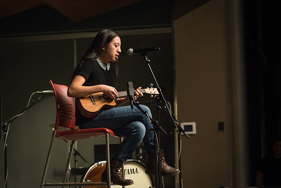 Students perform songs to an audience in the Crossroads at Acoustic Cafe.