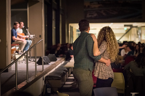 A couple stands up and dances to the music at Acoustic Cafe.