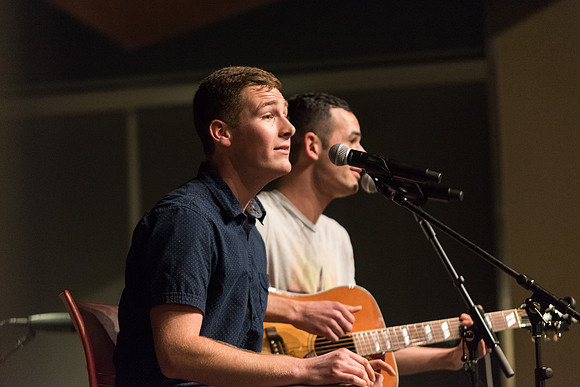 Students perform songs to an audience in the Crossroads at Acoustic Cafe.