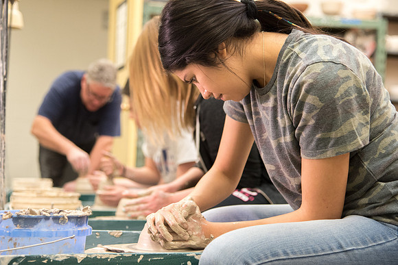 Students work on their clay projects in beginning ceramics class.