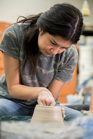 Students work on their clay projects in beginning ceramics class.