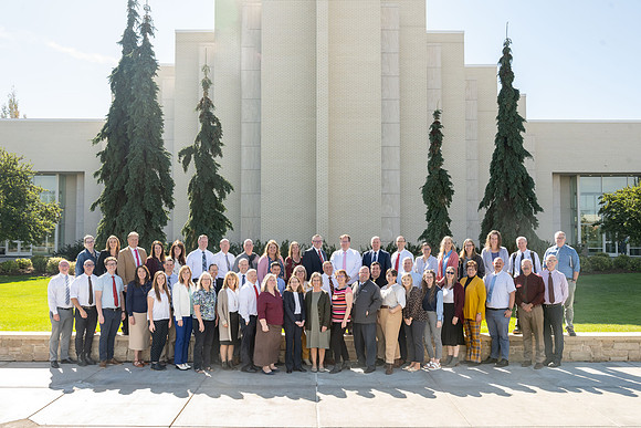 Employees of the online learning group stand outside the Taylor Building for a group photo.