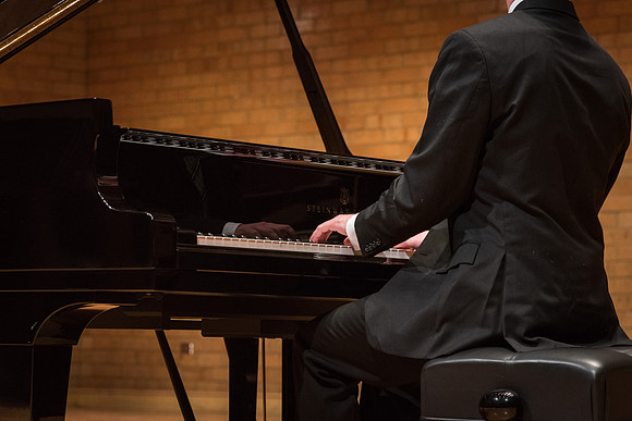 Doug Rowen, a music major, plays the Hamburg Steinway Piano in the Barrus Hall. 2018