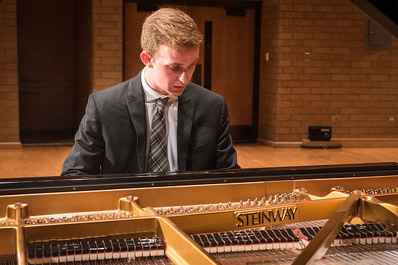 Doug Rowen, a music major, plays the Hamburg Steinway Piano in the Barrus Hall. 2018