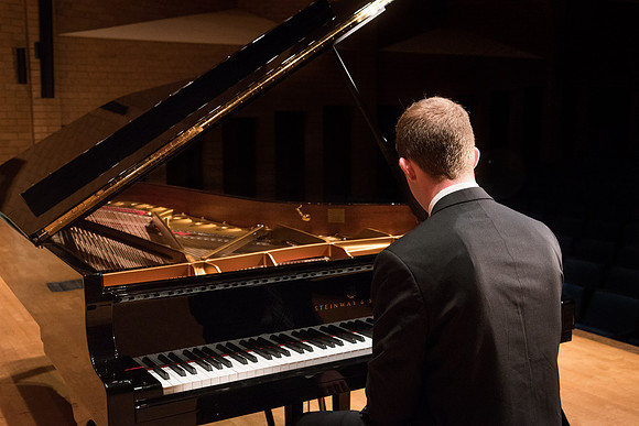 Doug Rowen, a music major, plays the Hamburg Steinway Piano in the Barrus Hall. 2018