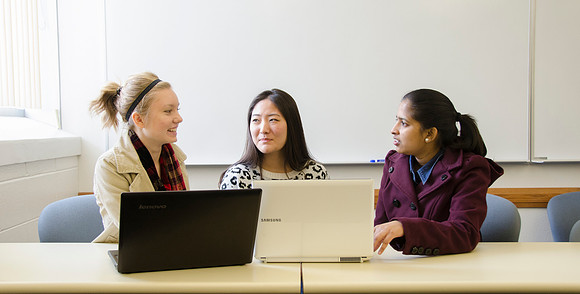 Three female students collaborate in a beginning software development.