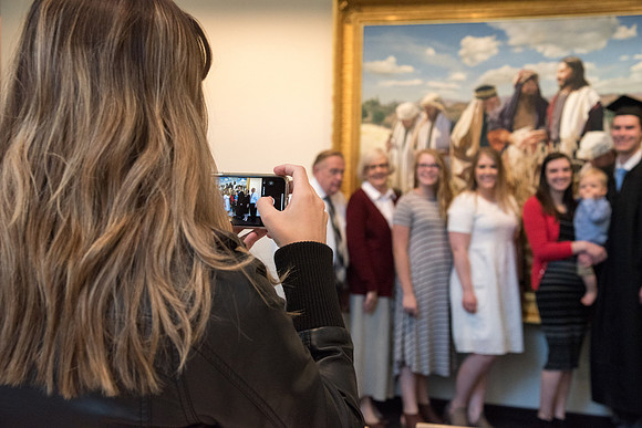 BYU-Idaho graduates with their family on campus.