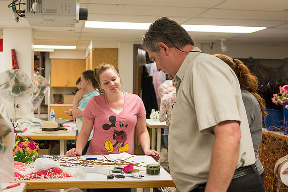 Horticulture students prepare for a semester review fashion show that will show their floral designs as well. Brother Romney leads the students along with other instructors.