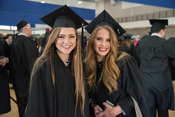 Graduates, Kaitlyn Neeley on left with friend meet in the I-Center Courts for Processional before Commencement begins. April 2018