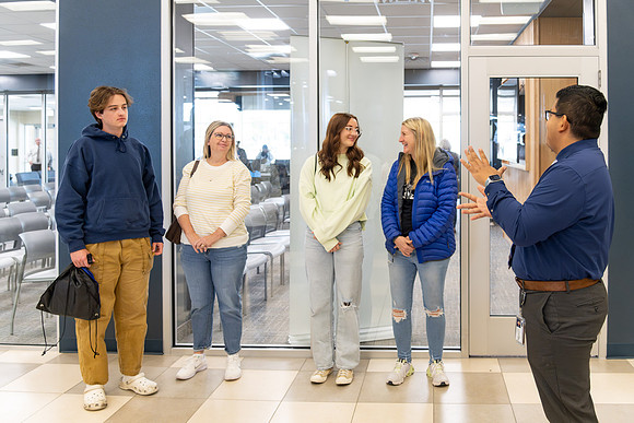 Employee giving a tour around campus to prospective students and their parents.
