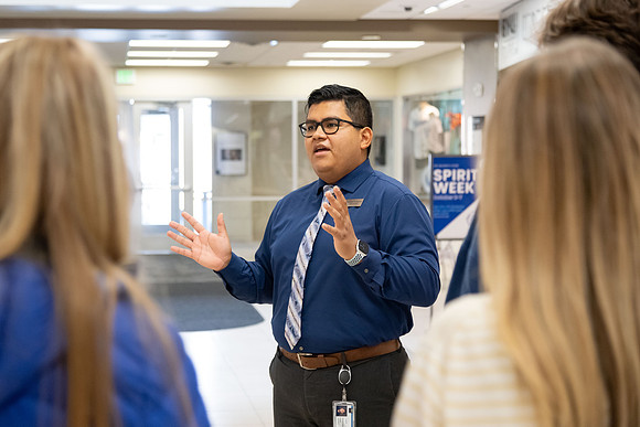 Employee giving a tour around campus to prospective students and their parents.