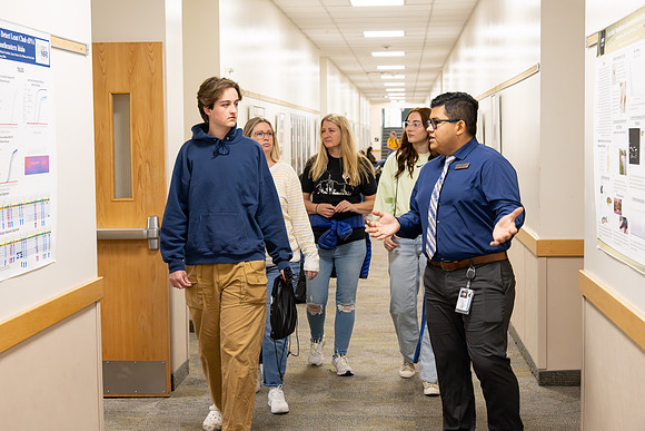 Employee giving a tour around campus to prospective students and their parents.
