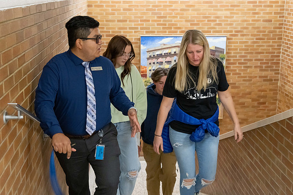 Employee giving a tour around campus to prospective students and their parents.