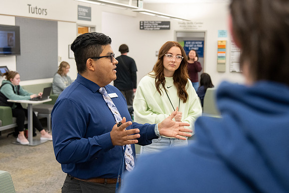Employee giving a tour around campus to prospective students and their parents.