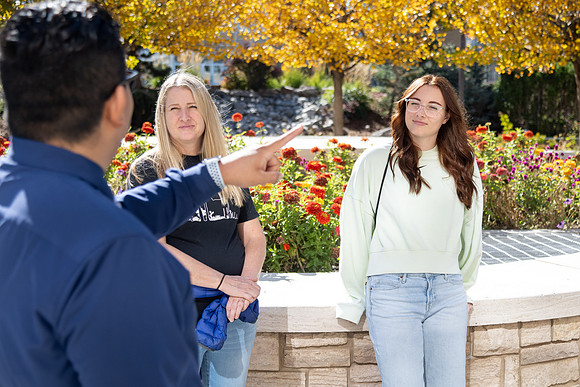 Employee giving a tour around campus to prospective students and their parents.