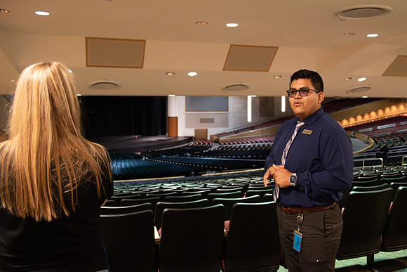 Employee giving a tour around campus to prospective students and their parents.