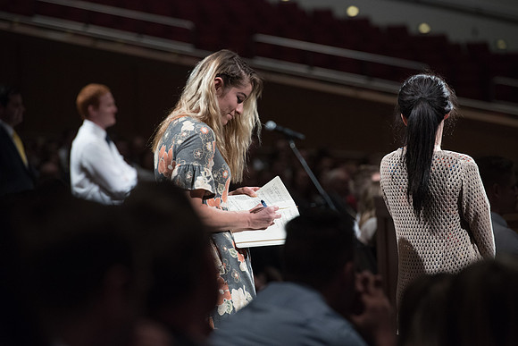 A married student writing down the advice that was given from a question in the I-Center. May 2018