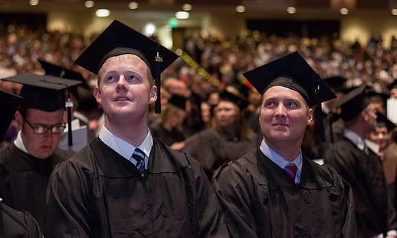Students look up at the Television in the i-Center during the Commencement Ceremony in the 2014 Winter Semester Graduation.