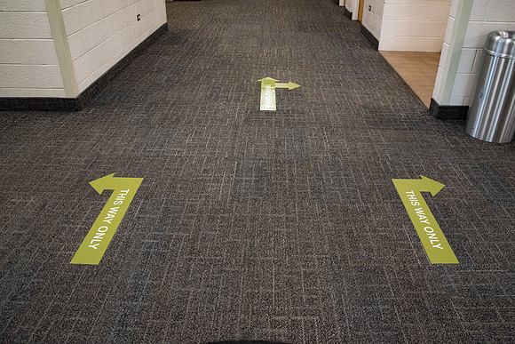 Stickers in the Taylor Building showing which way to walk down the hallways. The stickers are to direct foot traffic through buildings to try to help fight the virus, COVID-19, on campus.