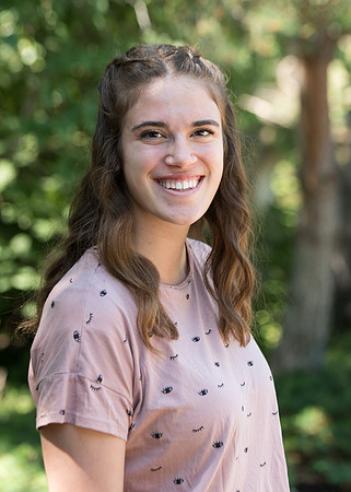 Rachel Oickle smiles for a photo in the gardens on campus and is a Financial Aid recipient.