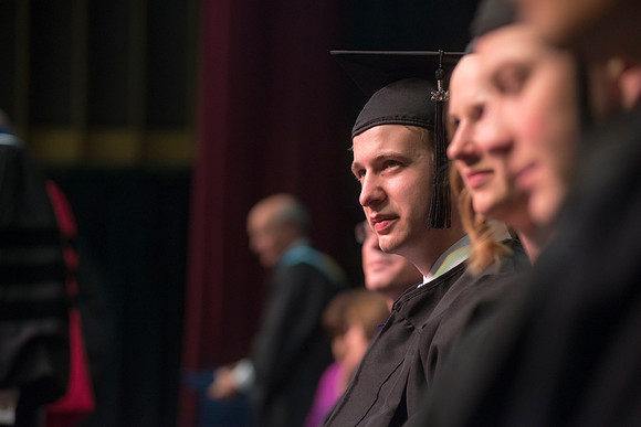 Elder W. Craig Swick and President Kim B. Clark award diploma covers to graduates in the College of Business and Communication.