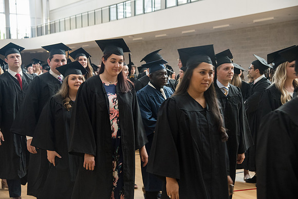 Graduates gather for procession before Commencement Services in the BYU-Idaho Center Courts.