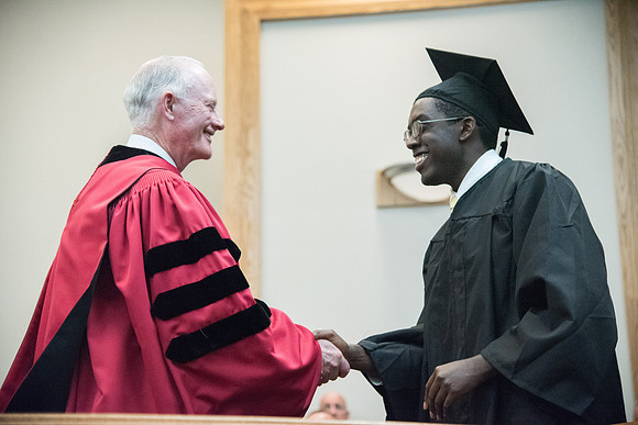 Graduates shake Elder Kim B. Clark's hand before being awarded their Diploma at Convocation of the Sociology and Social Work/Psychology in the Hinckley Chapel. July 2018