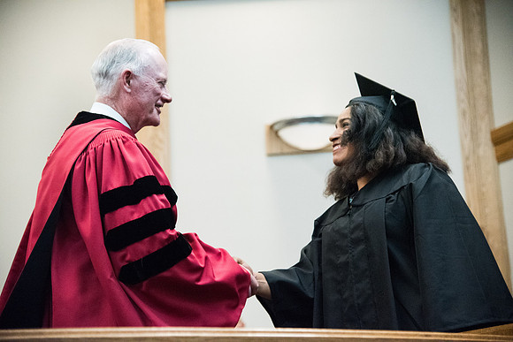 Graduates shake Elder Kim B. Clark's hand before being awarded their Diploma at Convocation of the Sociology and Social Work/Psychology in the Hinckley Chapel. July 2018