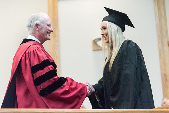 Graduates shake Elder Kim B. Clark's hand before being awarded their Diploma at Convocation of the Sociology and Social Work/Psychology in the Hinckley Chapel. July 2018