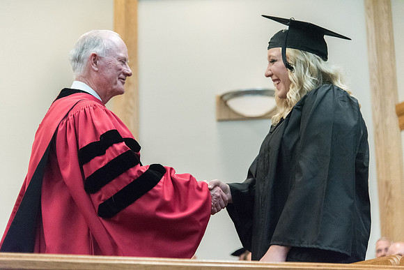 Graduates shake Elder Kim B. Clark's hand before being awarded their Diploma at Convocation of the Sociology and Social Work/Psychology in the Hinckley Chapel. July 2018