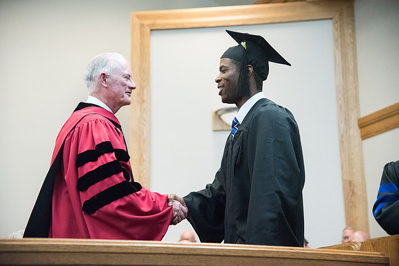 Graduates shake Elder Kim B. Clark's hand before being awarded their Diploma at Convocation of the Sociology and Social Work/Psychology in the Hinckley Chapel. July 2018