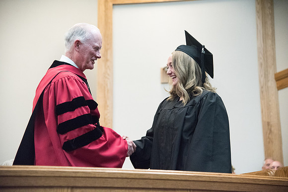 Graduates shake Elder Kim B. Clark's hand before being awarded their Diploma at Convocation of the Sociology and Social Work/Psychology in the Hinckley Chapel. July 2018