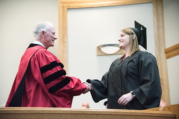 Graduates shake Elder Kim B. Clark's hand before being awarded their Diploma at Convocation of the Sociology and Social Work/Psychology in the Hinckley Chapel. July 2018