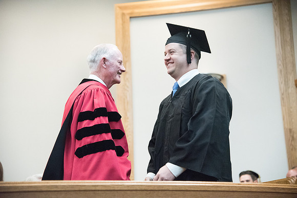 Graduates shake Elder Kim B. Clark's hand before being awarded their Diploma at Convocation of the Sociology and Social Work/Psychology in the Hinckley Chapel. July 2018