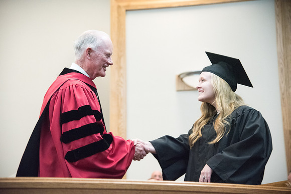 Graduates shake Elder Kim B. Clark's hand before being awarded their Diploma at Convocation of the Sociology and Social Work/Psychology in the Hinckley Chapel. July 2018